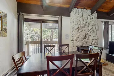 a dining room with a table and chairs and a stone wall at Horizons 4 160 in Mammoth Lakes