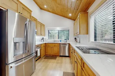 a kitchen with wooden cabinets and a stainless steel refrigerator at Gold Bear in Truckee