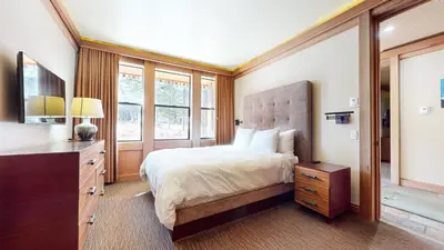a bedroom with a bed and a dresser and windows at Obsidian #1 home in Mammoth Lakes