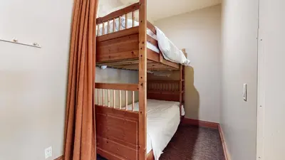 a bunk bed in a room with a ladder at Obsidian #1 home in Mammoth Lakes