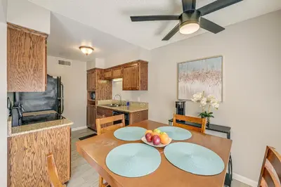 a kitchen with a dining room table with a ceiling fan at Cozy Fresno Condo with Balcony and Pool Access in Fresno