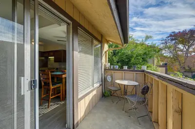 a patio with a table and chairs on a balcony at Cozy Fresno Condo with Balcony and Pool Access in Fresno