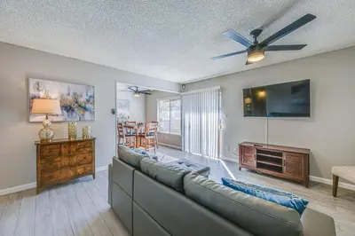a living room with a couch and a ceiling fan at Cozy Fresno Condo with Balcony and Pool Access in Fresno