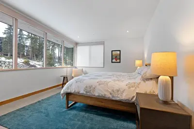 a bedroom with a bed and a table with a lamp at Stellar Ski-in Ski-out Out # 2 at Northstar 2 by Tahoe Getaways - Pet-Friendly 3BR Townhome w Loft, Shuttle and HOA! in Truckee-Tahoe Airport
