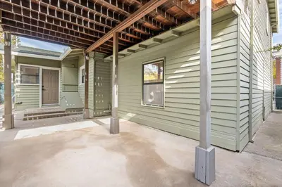 a green house with a porch and a pole at Downtown Lodi l Renovated l 5 Bedrooms l Sleeps 10 in Lodi