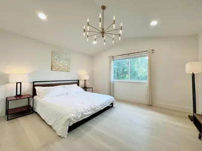 a bedroom with a large bed and a chandelier at Trendy Trenholm in Elk Grove