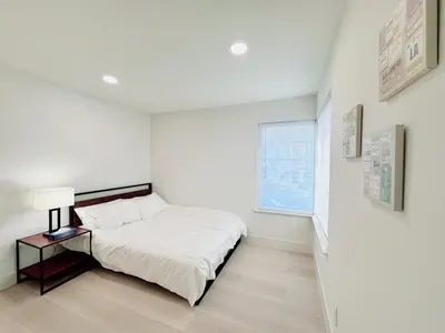 a white bedroom with a bed and a window at Trendy Trenholm in Elk Grove