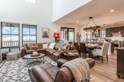 a living room with leather furniture and a kitchen at Creekhouse 1364 in Mammoth Lakes