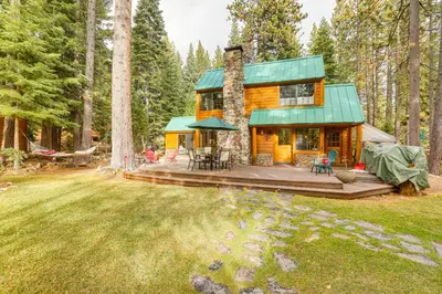 a cabin in the woods with a deck and chairs at Less Than 1 Mi to Lake Tahoe Beaches Home with Fire Pit! in Tahoe City