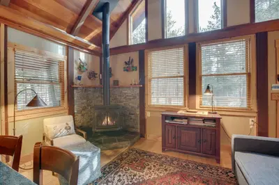 a living room with a fireplace and wooden ceilings at Less Than 1 Mi to Beach Peaceful Studio with Deck in Tahoma in Tahoma