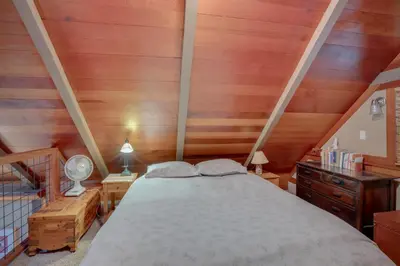 a bedroom with a bed and wooden walls at Less Than 1 Mi to Beach Peaceful Studio with Deck in Tahoma in Tahoma