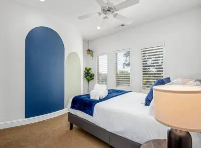 a bedroom with a blue accent wall and a bed at Luxury 4 Acre Estate - Pickleball, Pool, Hot Tub! in Lockeford
