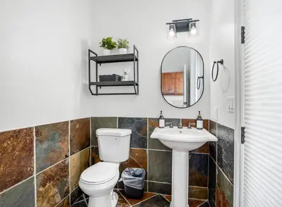 a bathroom with a toilet and a sink at Luxury 4 Acre Estate - Pickleball, Pool, Hot Tub! in Lockeford