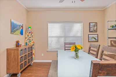 a dining room with a table and a surfboard at Yosemite Bass Lake Adventure Oasis in Bass Lake