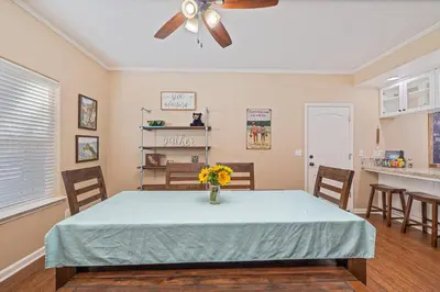 a dining room with a table with a vase of flowers on it at Yosemite Bass Lake Adventure Oasis in Bass Lake