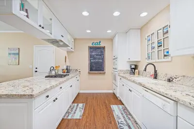 a kitchen with white cabinets and a chalkboard on the wall at Yosemite Bass Lake Adventure Oasis in Bass Lake