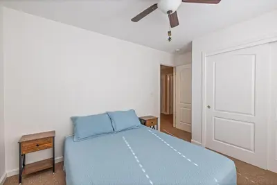 a bedroom with a blue bed and a ceiling fan at Yosemite Bass Lake Adventure Oasis in Bass Lake
