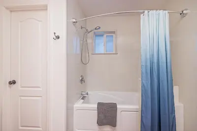 a bathroom with a tub and a shower with a shower curtain at Yosemite Bass Lake Adventure Oasis in Bass Lake