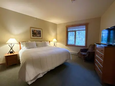 a bedroom with a bed and a flat screen tv at Ski-in/Ski-out with views at Sunstone in Mammoth Lakes