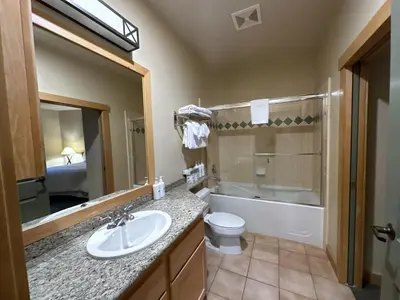 a bathroom with a sink and a toilet and a mirror at Ski-in/Ski-out with views at Sunstone in Mammoth Lakes