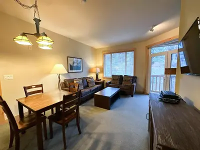 a living room with a table and a couch at Ski-in/Ski-out with views at Sunstone in Mammoth Lakes