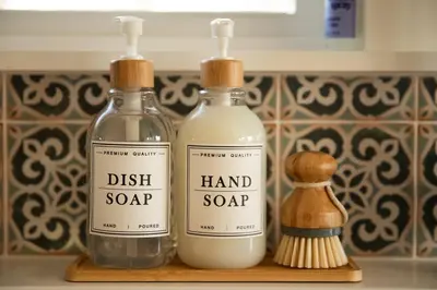 two bottles of hand soap and a brush on a counter at Reno's Biggest Little House - Cozy Home Theatre in Reno
