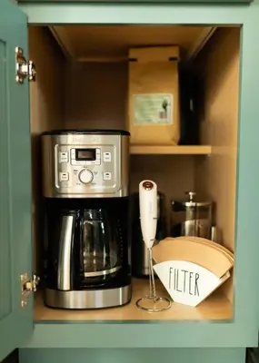 a cupboard with a coffeemaker and a coffee maker at Reno's Biggest Little House - Cozy Home Theatre in Reno