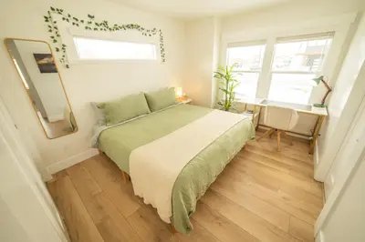 a bedroom with a bed and a desk and windows at Reno's Biggest Little House - Cozy Home Theatre in Reno