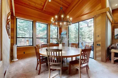 a dining room with a table and chairs and windows at Timberline Daydream in Truckee