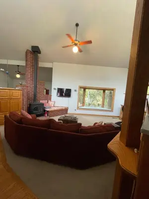 a living room with a couch and a ceiling fan at RiverFront Retreat- Spa/Hot tub, Game Room, Limited Gym in Three Rivers