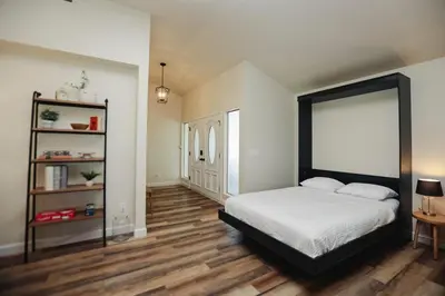 a bedroom with a bed and a wooden floor at Riverfront Beauty with Pickle Ball Court in Kingsburg