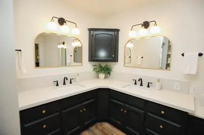 a bathroom with two sinks and two mirrors at Riverfront Beauty with Pickle Ball Court in Kingsburg