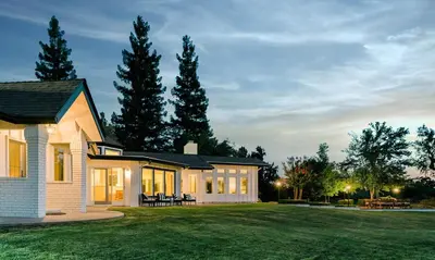 a house with a lawn in front of it at Riverfront Beauty with Pickle Ball Court in Kingsburg