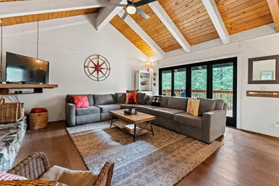 a living room with a couch and a table at Trailblazer Chalet at Olympic Valley with Private Hot Tub and Ski Shuttle in Alpine Meadows