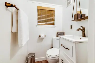 a white bathroom with a toilet and a sink at 3 Mi to Calaveras Big Trees Cabin with Fire Pit! in Arnold