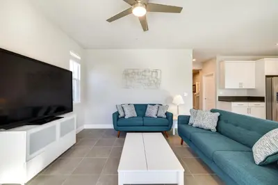 a living room with a blue couch and a flat screen tv at Stylish Lodi Wine Country Retreat with Private Patio in Lodi