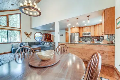 a kitchen and living room with a wooden table and chairs at Family Cabin with Community Perks in Truckee! in Truckee