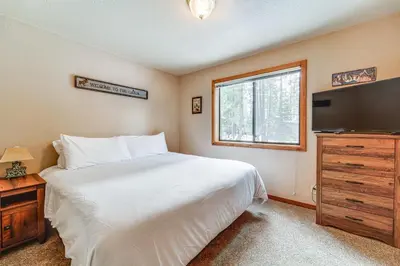 a bedroom with a white bed and a television at Family Cabin with Community Perks in Truckee! in Truckee