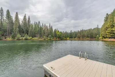 a dock in the middle of a lake with trees at Oso Borracho in Arnold