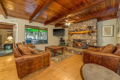 a living room with leather furniture and a stone fireplace at Oso Borracho in Arnold