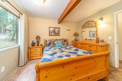 a bedroom with a wooden bed and a window at Oso Borracho in Arnold