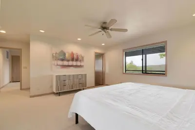 a bedroom with a white bed and a ceiling fan at Murphys View in Murphys