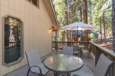a patio with a table and chairs and an umbrella at Moonlit Pines in Camp Connell