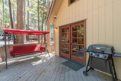 a grill on a deck next to a house at Moonlit Pines in Camp Connell