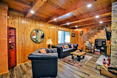 a living room with leather furniture and wooden walls at Grey Wolf Manor in Arnold