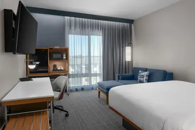 a hotel room with a bed and a desk with a computer at Courtyard by Marriott Modesto North in Modesto