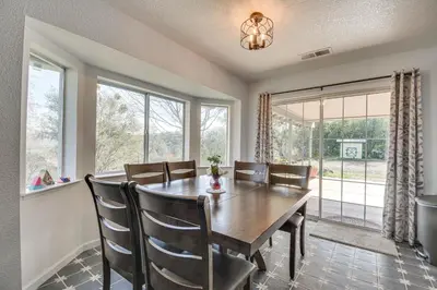 a dining room with a table and chairs and windows at Bright and Cozy Mariposa Getaway 46 Mi to Yosemite! in Mariposa