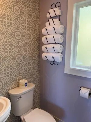 a bathroom with a toilet and a pile of towels at Sugarloaf Mountain Motel in Virginia City