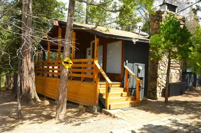 a small house with a sign on the front of it at Bear Paw- Lake Area Winter Special Ends 51526 in Bass Lake