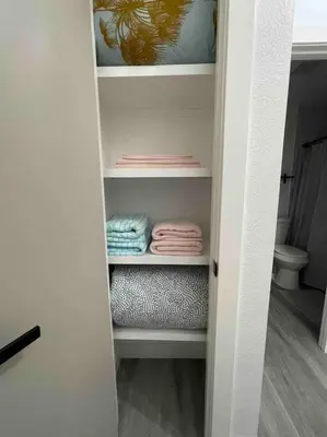 a closet with some folded towels and a toilet at Entire Modern House with King bed & 65inTV in Carmichael